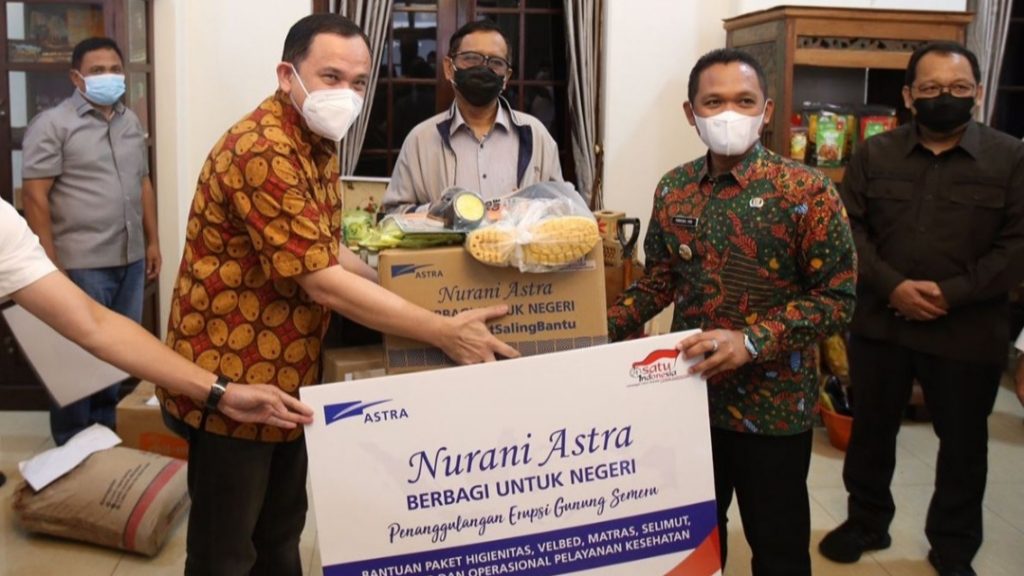 Peduli Semeru, Nurani Astra Salurkan Bantuan Tahap Awal Senilai Rp 4,4 Miliar Menkopolhukan Mahfud MD (tengah) menyaksikan penyerahan bantuan untuk korban bencana alam erupsi Gunung Semeru dari Astra yang diwakili oleh Chief of Corporate Affairs Astra Riza Deliansyah (kiri) kepada Bupati Lumajang Thoriqul Haq (kanan) di pendopo Kabupaten Lumajang, Jumat (17/12/2021)