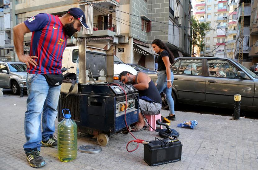 Lebanon Minta Kedutaan Cari Donor untuk Biayai Operasional Mereka Warga mencoba memperbaiki generator listrik bekas di dekat rumahnya, Lebanon, 10 Agustus 2021. Pemadaman listrik telah menjadi bagian dari kehidupan sehari-hari di Lebanon. Lebanon Minta Kedutaan Cari Donor untuk Biayai Operasional Mereka