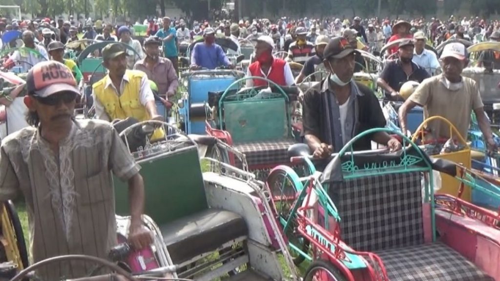 Ribuan tukang becak antre mendapatkan zakat dari seorang kepala desa di Kabupaten Jombang, Sabtu (30/4/2022). 