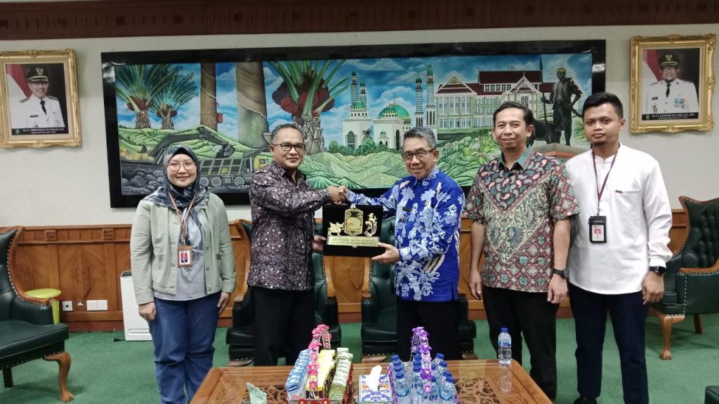 Parjiman, Kepala OJK Kaltimtara memberikan cinderamata kepada Bupati Kutim Ardiansyah Sulaiman dalam acara kunjungan OJK ke Kabupaten Kutim, Jumat (26/7/2024) (Ahmad/GOnews.id)