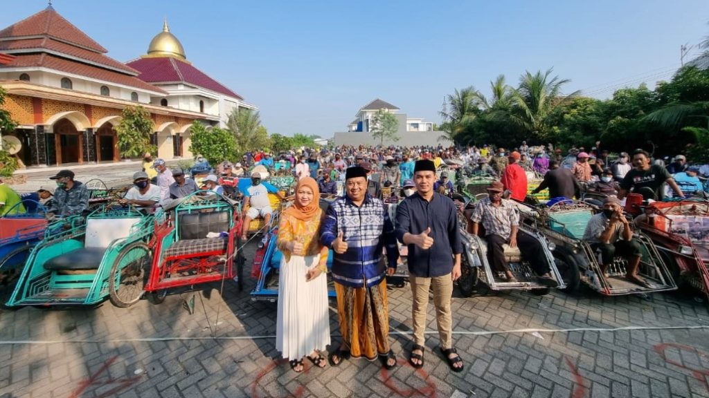 H Warsubi SH MSi didampingi putrinya ketua DPC Partai Gerindra Kabupaten Jombang Octadella Bilytha saat hendak membagikan zakat mall di halaman rumahnya di Desa Mojokrapak Kecamatan/ kabupaten Jombang, Sabtu (30/04/2022). (suaraindonesia)