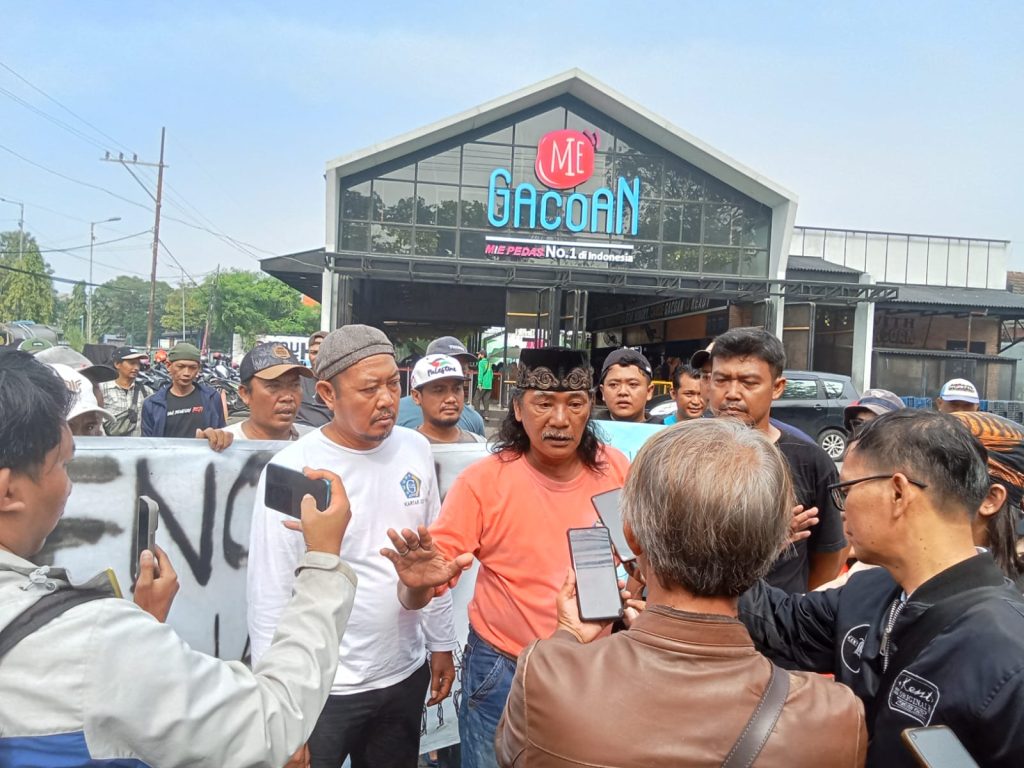 Kepala Desa Gelam Mochamad Muslich bersama puluhan Karang Taruna dalam demo penolakan peralihan sistem parkir,Jumat (24/1/2025)
