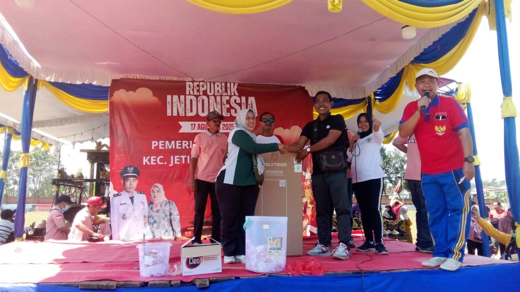 Kepala Desa Jetis, Sigit Purnomo saat memberikan hadiah dalam acara Blusukan Kampung Bangkit di Dusun Pelabuhan, Jetis, Mojokerto, Minggu (31/8/2025)