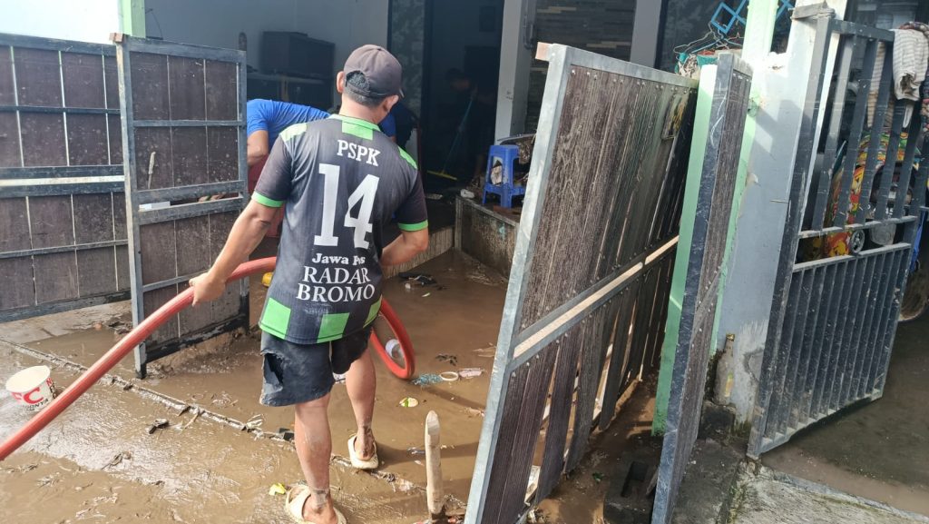 Foto Edi Mulyono.petugas BPBD Jember bantu warga bersihkan sisa banjir