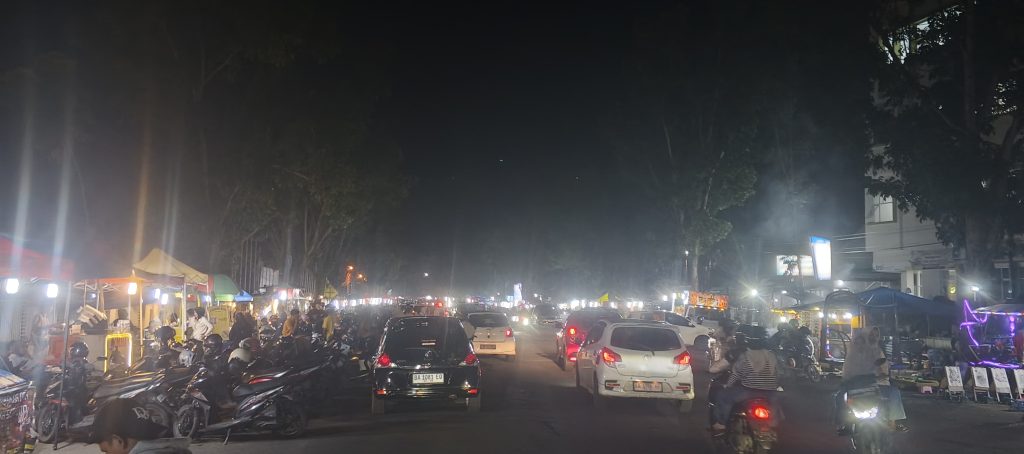 Suasana malam Minggu menjelang Tahun Baru 2026 di Jalur 32 dan halaman Kantor Bupati Pasaman Barat, di mana masyarakat berkumpul menikmati kuliner, hiburan, serta mainan anak-anak. Sabtu malam 27 Desember 2025. (Saipen/GOnews.id)
