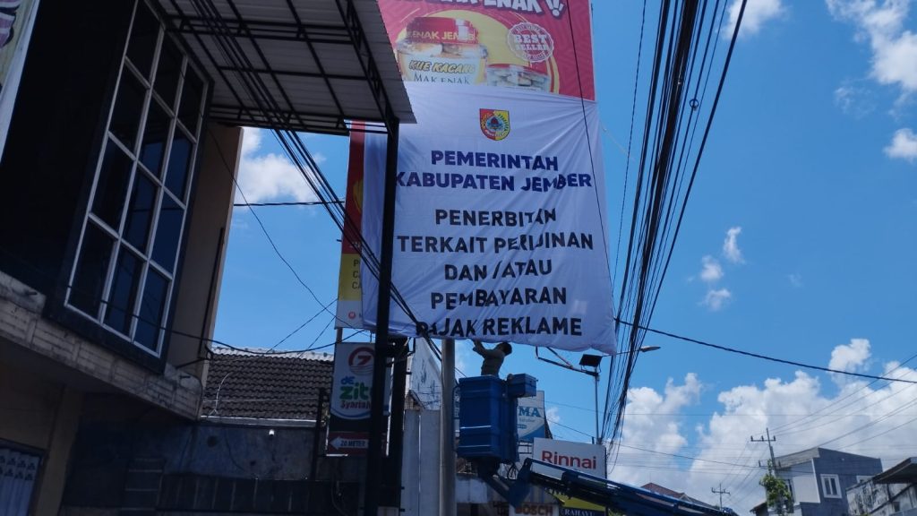 Petugas saat pasang himbauan penertiban ijin reklame di jalan Hos Cokroaminoto JEMBER. Foto Edi Mulyono