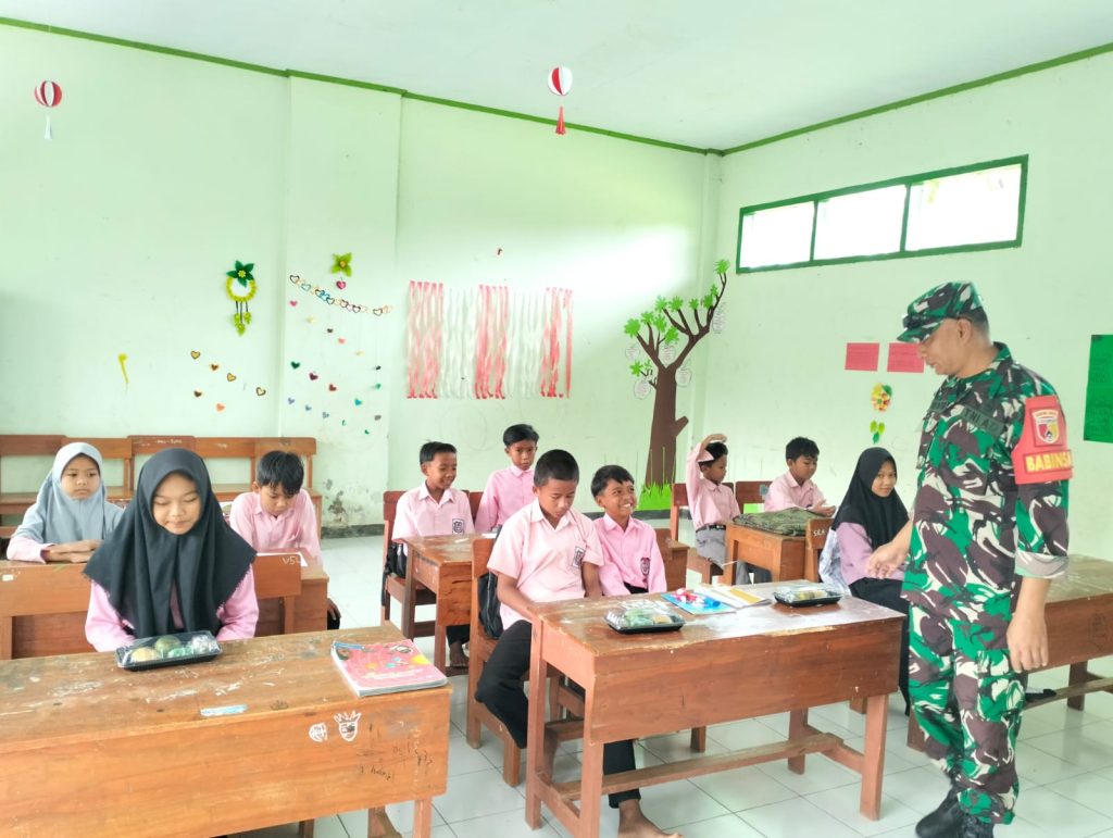 Babinsa Desa Nogosari Fadly Wahyudi mendampingi penyaluran paket makanan bergizi gratis