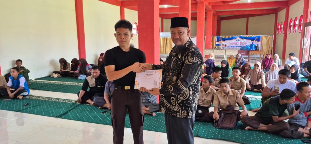 Kepala SMKN 1 Sasak Ranah Pesisir, Dr. Desman, S.Pd.I, MA, memberikan sambutan saat acara penutupan kegiatan Pesantren Ramadan yang berlangsung di aula sekolah, Jum’at (13/3/2026). (Fhoto : Dioni/Gonews.id)