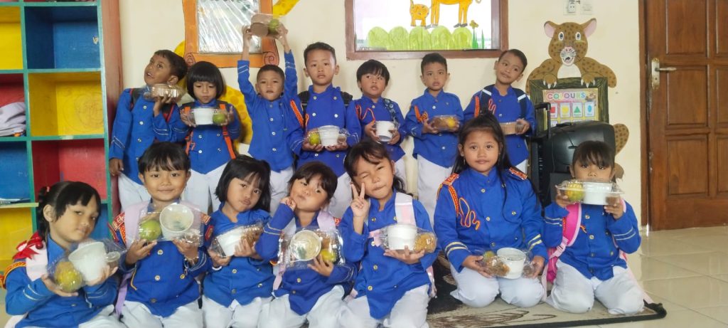 Siswa TK Al Kautsar Sukosari, Bondowoso, menunjukkan paket Makan Bergizi Gratis (MBG) dari dapur SPPG Sukosari Lor yang dibagikan pada Kamis (12/3/2026)