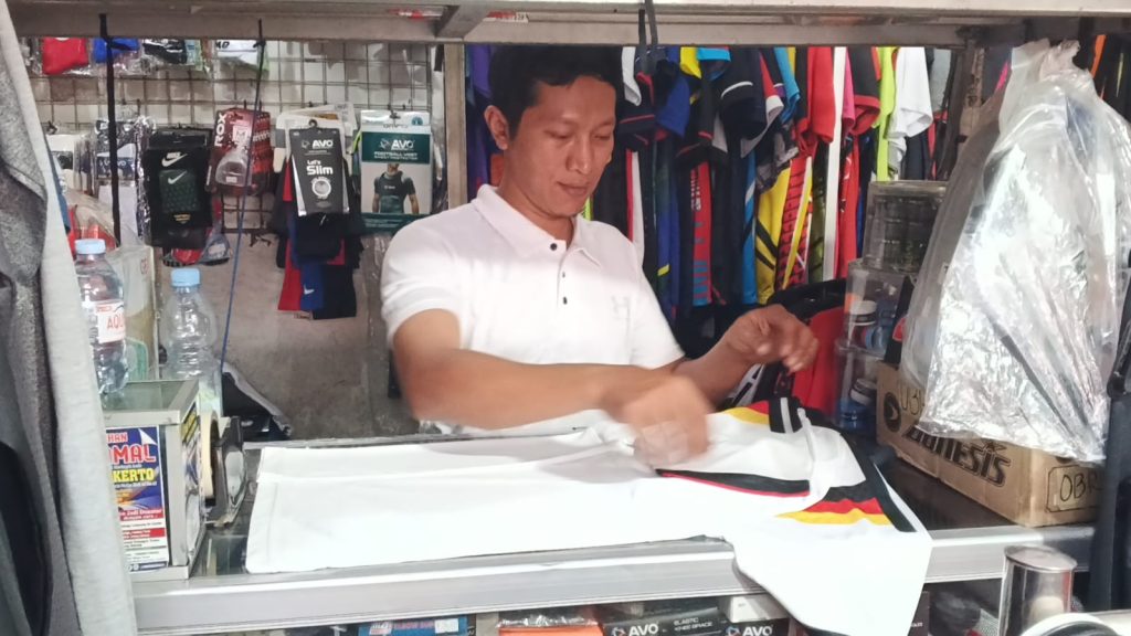 Faturrahman pemilik Yoga Sport sedang merapikan Jersey nasional Jerman salah satu peserta piala dunia 2026