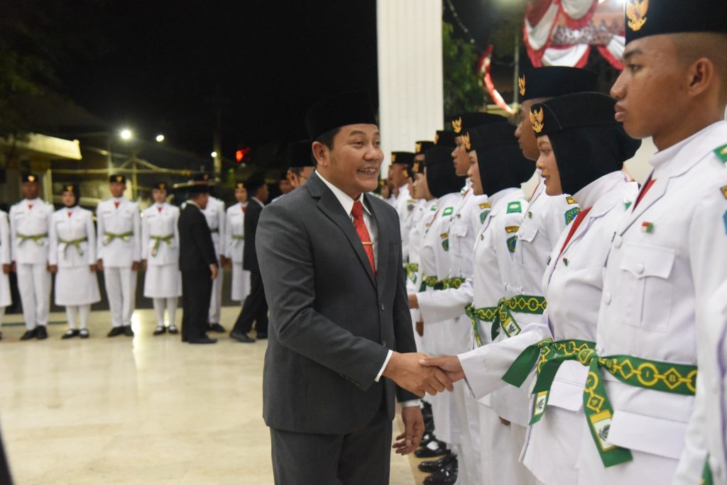 77 Paskibraka Sidoarjo Dikukuhkan, Siap Bertugas Bupati Sidoarjo H. Subandi menyematkan tanda Paskibraka kepada salah satu anggota saat pengukuhan 77 Paskibraka Kabupaten Sidoarjo di Pendopo Delta Wibawa, Sabtu (15/8/2026) malam.