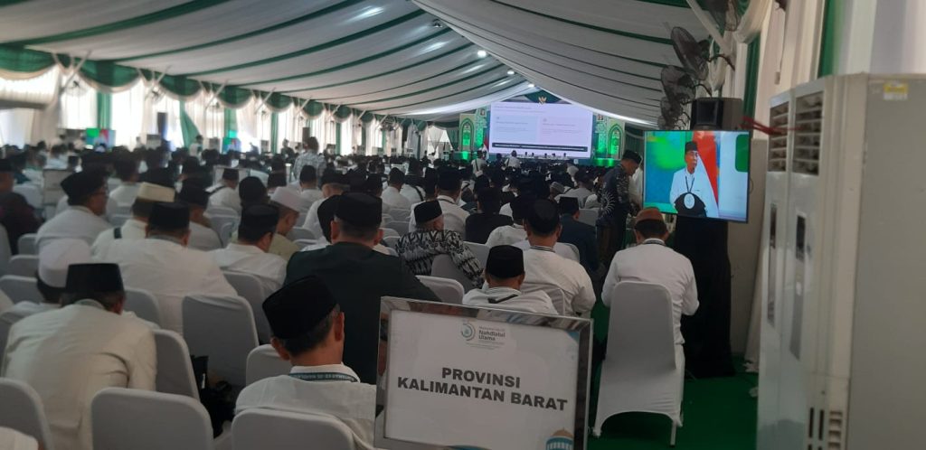 Suasana Sidang Pleno Muktamar NU ke-35 saat Ketua Umum PBNU Gus Yahya menyampaikan pandangan mengenai perjalanan sejarah berdirinya NU sebelum LPJ PBNU diterima peserta. Persidangan berlangsung aman dan kondusif.