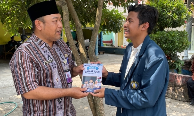 Penyerahan Buku Modul Edukasi Gemarikan secara simbolis oleh perwakilan mahasiswa PKM-Bahari FPIK UB, Wira, kepada Kepala SDN 2 Curungrejo, Bapak Irwan Meirikha.